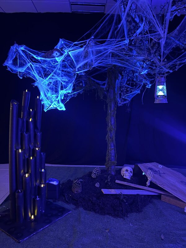 L’arbre aux toiles d’araignée vu sous lumière bleue, lanterne suspendue et colonne de bougies LED
