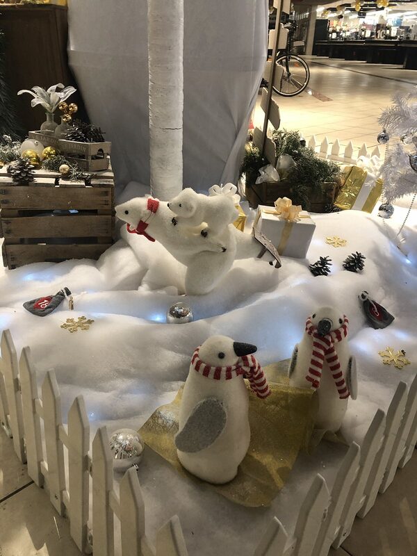 Ours polaires et pingouins à écharpes rayées sur un tapis de neige, cagette en bois garnie de pommes de pin et de boules dorées