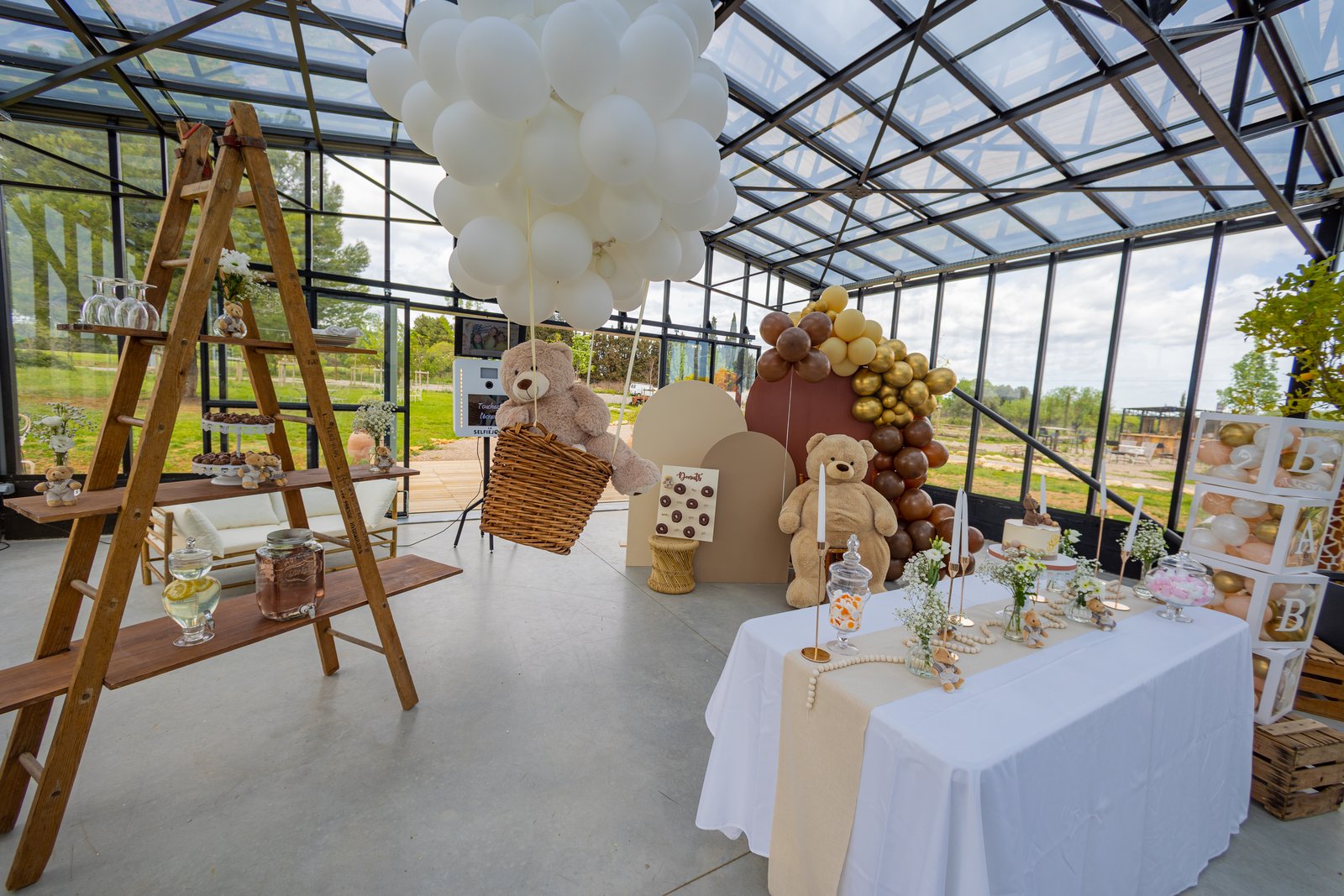 Échelle en bois à plateaux, montgolfière de ballons blancs avec nounours, buffet blanc et cubes B-A-B-Y sous une verrière