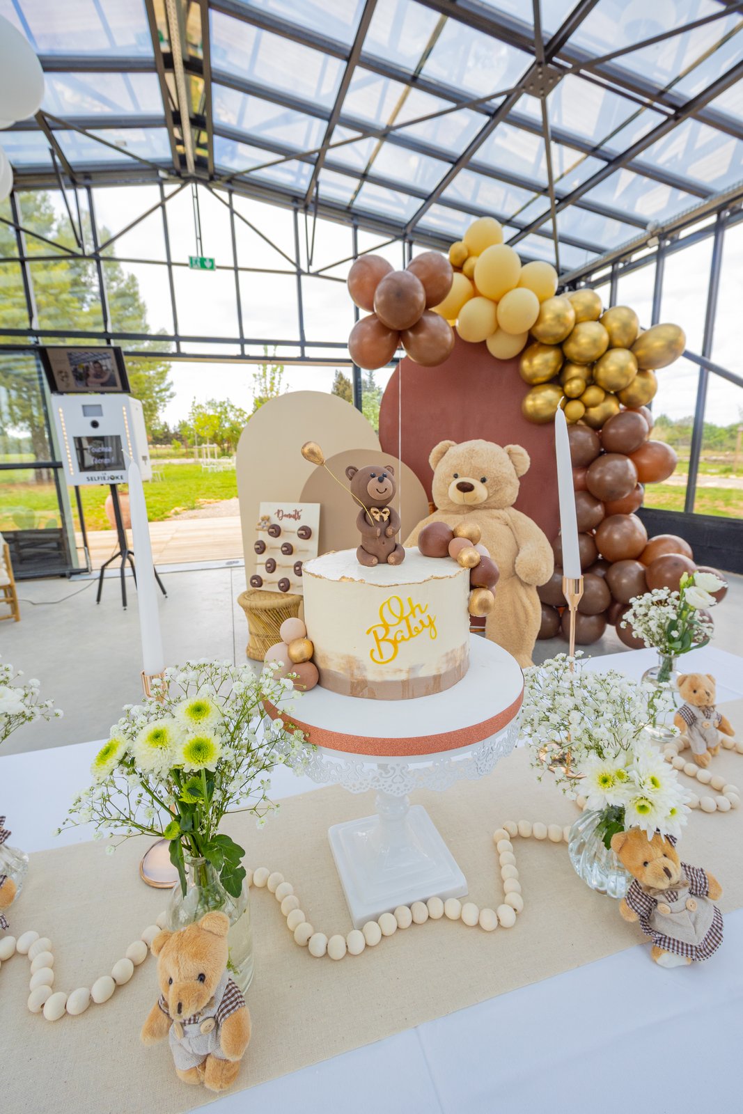 Gâteau « Oh Baby » surmonté d’un ourson, bouquets de marguerites, petits nounours et guirlande de perles en bois